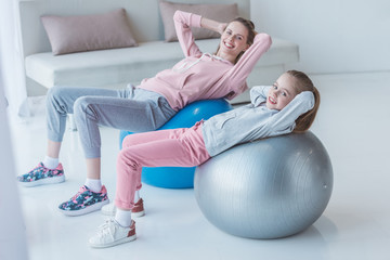 mother and daughter working out with fit balls at home