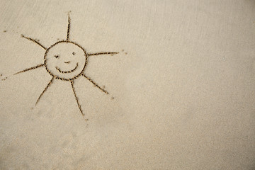 Sun drawing in the sand at the caribbean beach. Travel background.