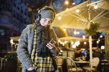 teenager boy with smartphone and headphones in the street