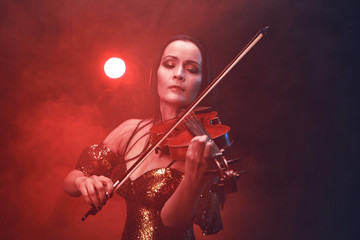 Violinist girl performs on stage.