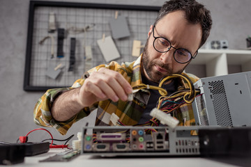 man adjusting details while fixing computer