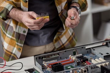 cropped image of repairman attachments to screwdriver in hands