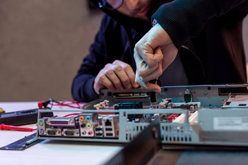 cropped image of man fixing computer
