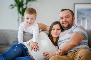 Picture of happy family with son sitting on sofa