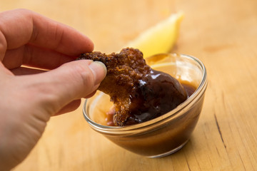 Frau isst Chicken Wings mit BBQ Dip