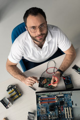man using multimeter while testing hard disk drive