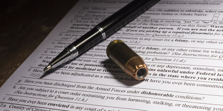 Cartridge and pen on gun paperwork with dishonorable discharge question