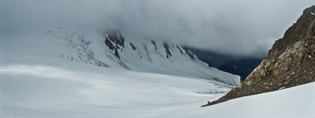 Fototapeta na wymiar Snow mountains in the clouds, panorama