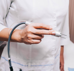 rejuvenation procedure , a woman beautician cosmetologist holds a mesotherapy apparatus