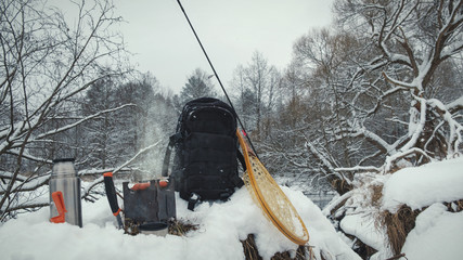 A picnic on a fishing trip, on a snow-covered winter river.