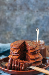 Chocolate fluffy pancakes with chocolate sauce. Blue background.