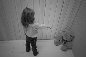 punishes, puts in the corner of the toy bear girl, child