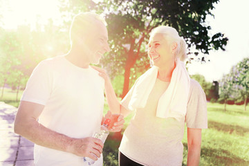 In love. Waist up of cheerful elderly couple looking at each other while showing true feelings