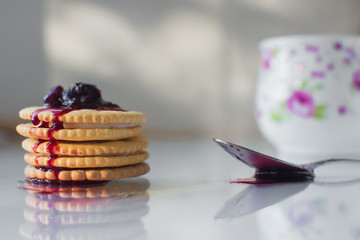cookies with filling next with a glass of milk nicely at home, on top of the jam