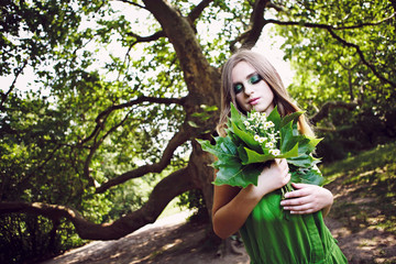 Красивая женщина с длинными волосами. Портрет на открытом воздухе в зеленом платье.