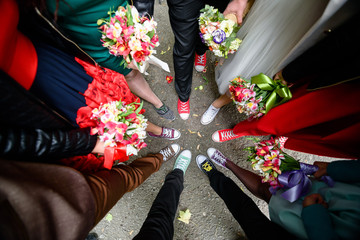 Original wedding photo with feet in colorful sneakers standing in circle - obrazy, fototapety, plakaty