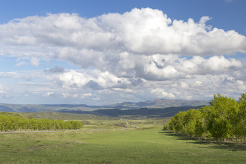 Country road in the mountains under the sky with clouds and clouds
