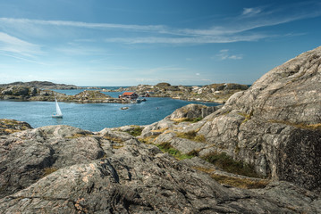 Sea landscape with sailboat and rocky coastline on the South of Sweden. Southern coastline of Sweden with view at sailing-ship and rocky islands.