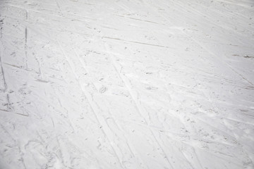Ski traces on white snow in mountains at sunny day