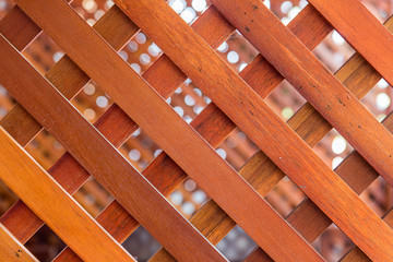 Diagonal line of planks in the barrier. A view through a hole in a fence to another fence.