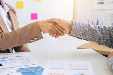 Obraz na płótnie Canvas Two business people shaking hands during a meeting to sign agreement and become a business partner in the office, success, dealing, greeting & business partner concept, contract between their firms