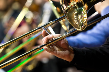Fototapeta premium Trombone in the hands of a musician in a closeup orchestra 