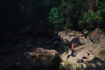 Tourist sit on dry waterfall stones