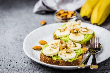 Avocado banana toasts on concrete background. Selective focus ,copy space.