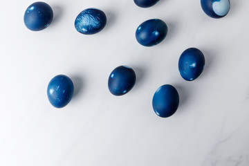 top view of blue painted easter eggs on white surface