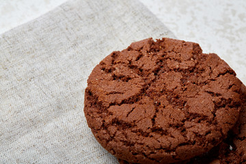 Closeup shallow depth of field picture of freshly baked chocolate chip cookies on burlap napkin.