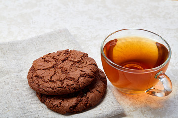 Top view close up picture of tea in transparent cup with biscuit cookies on a cotton napkin isolated on white background