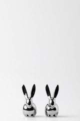 Two statuettes of easter bunnies on white