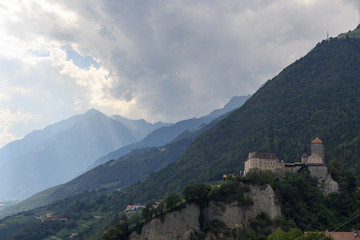 Fototapeta na wymiar Tyrol Castle, dark storm clouds and mountain panorama in Tirol, South Tyrol
