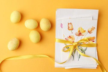 top view of yellow painted easter eggs with postcards on yellow