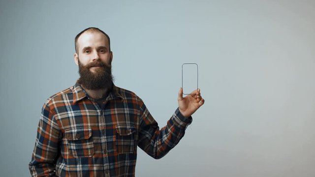 Closeup of confident bearded man showing a small empty frame blank copy space for your product