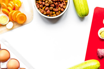 sliced vegetables and petfood on kitchen table background top vi