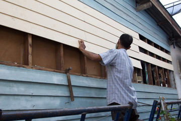 A carpenter is repairing the house.