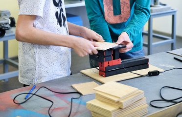 Children work in the training center on wood processing machines. Education in Fablab. Innovative...