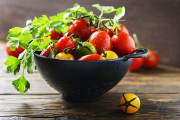 Mix of red, yellow and green tomatos with parley, selective focus