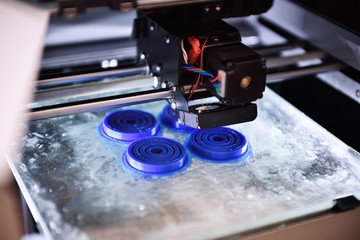 The 3D printer prints the details of the blue plastic. 3D printing of ABS or PLA plastic on a...
