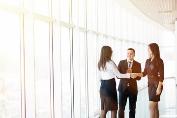 So nice to meet you. Young beautiful women shaking hands with smile while standing at the office