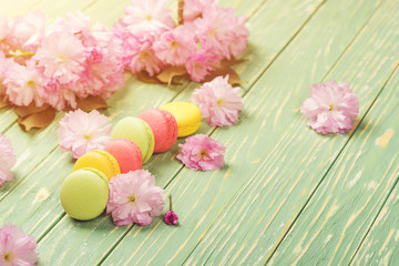 Flower and macarons pattern on a greenery background.