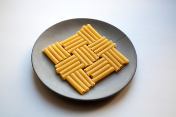 Cannelloni pasta chessboard patterned square isolated on grey concrete plate