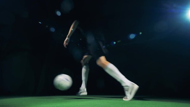 Professional soccer player is rushing into the picture, getting the ball, juggling and rushing out. 