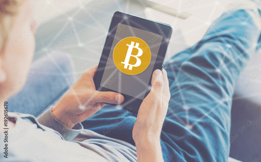 Poster bitcoin with man using a tablet in a chair