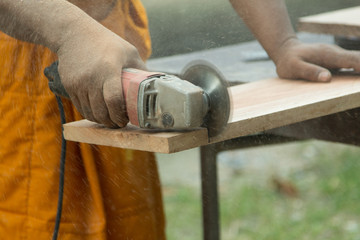 A carpenter is Sawing the wood.
