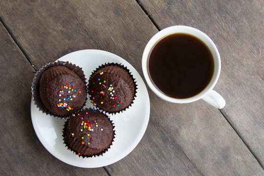 Coffee break serve chocolate cupcakes and black coffee.