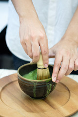 Hands stirring green tea powder