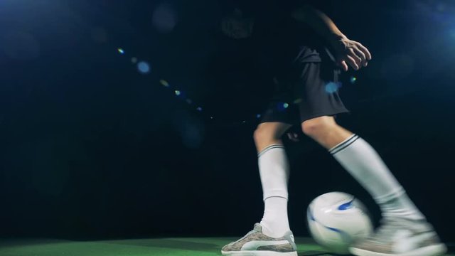 Professional soccer player is rushing into the picture, getting the ball and making tricks. 