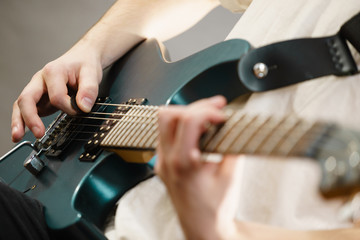 Fototapeta na wymiar Close up of man playing on electric guitar